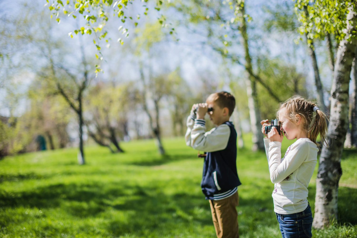 Kids pointing excitedly at a bird in a vibrant, biodiverse backyard setting